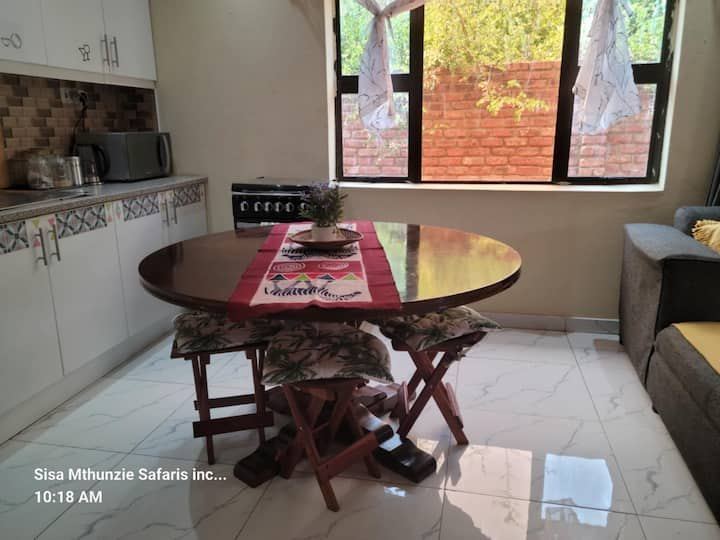 Dining table laid for four in the open-plan living area of Granadilla Cottage