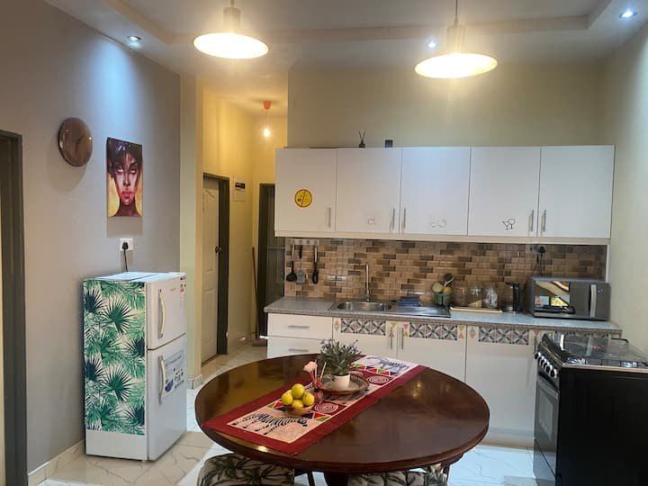 Open-plan kitchen and wooden dining table at Granadilla Cottage in Victoria Falls