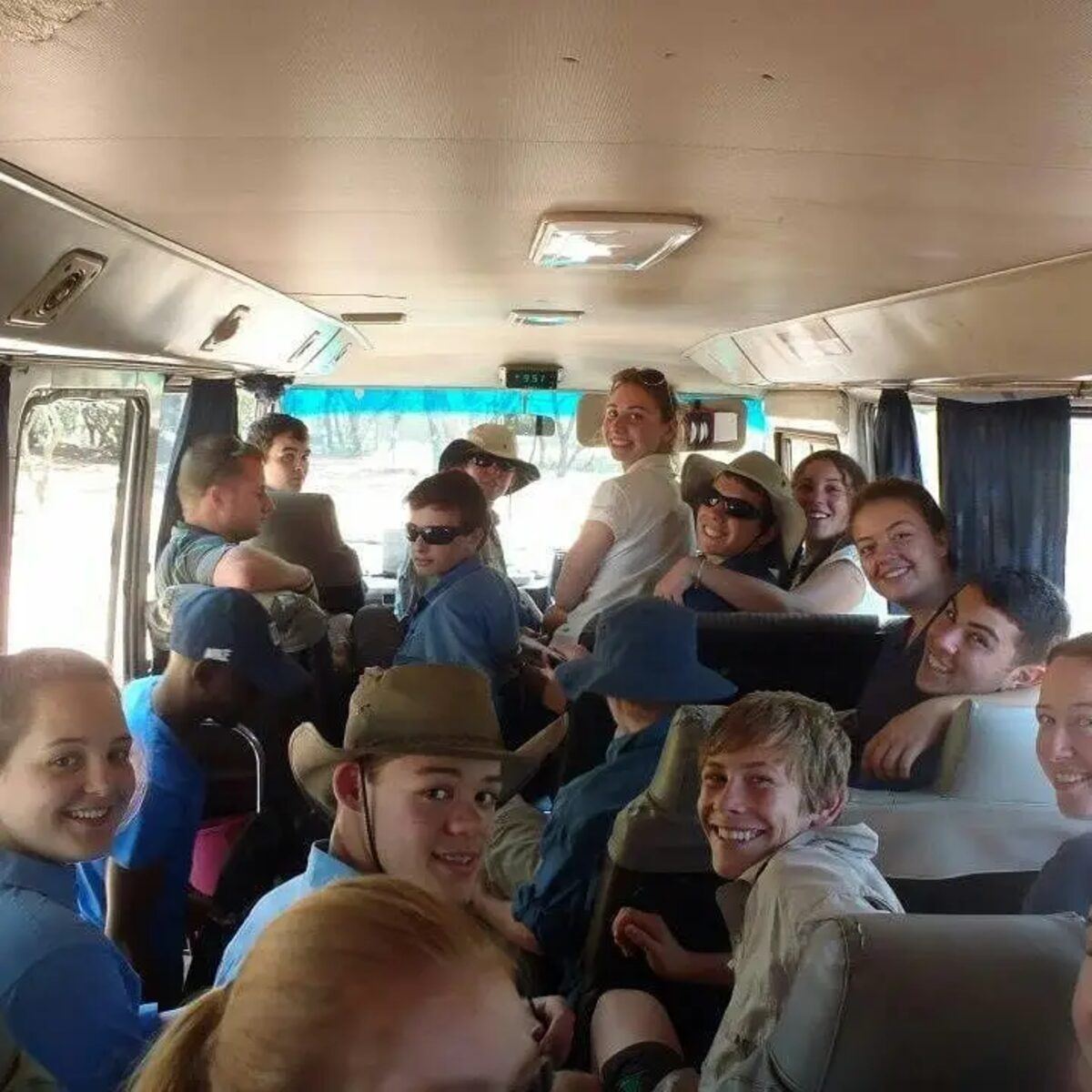 A large group of guests smiling inside an Excellence Trails tour bus