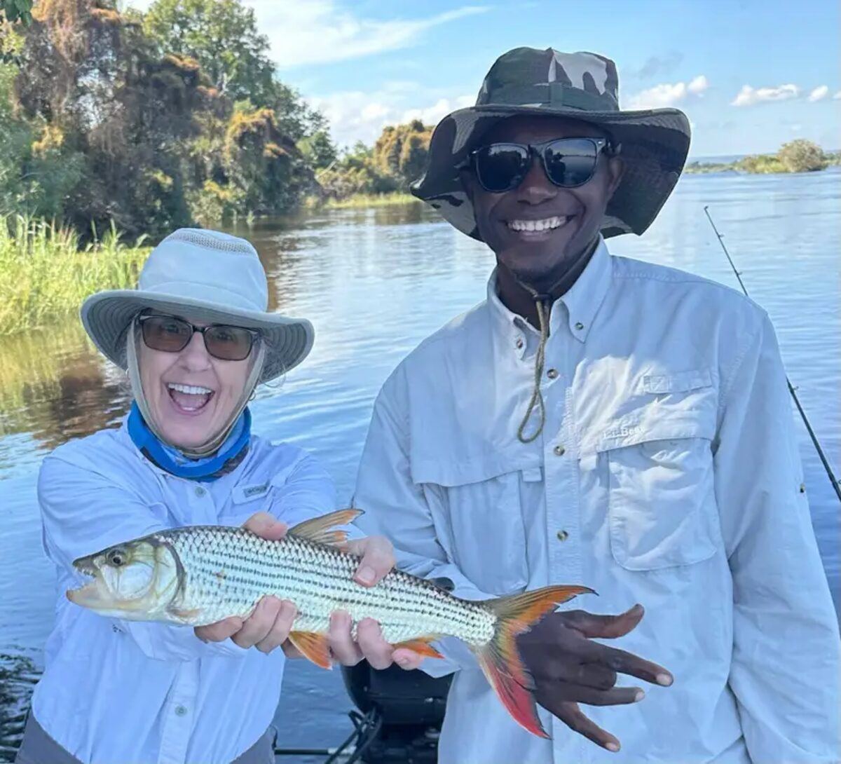 Guests holding a large tigerfish caught on the Zambezi River with their guide