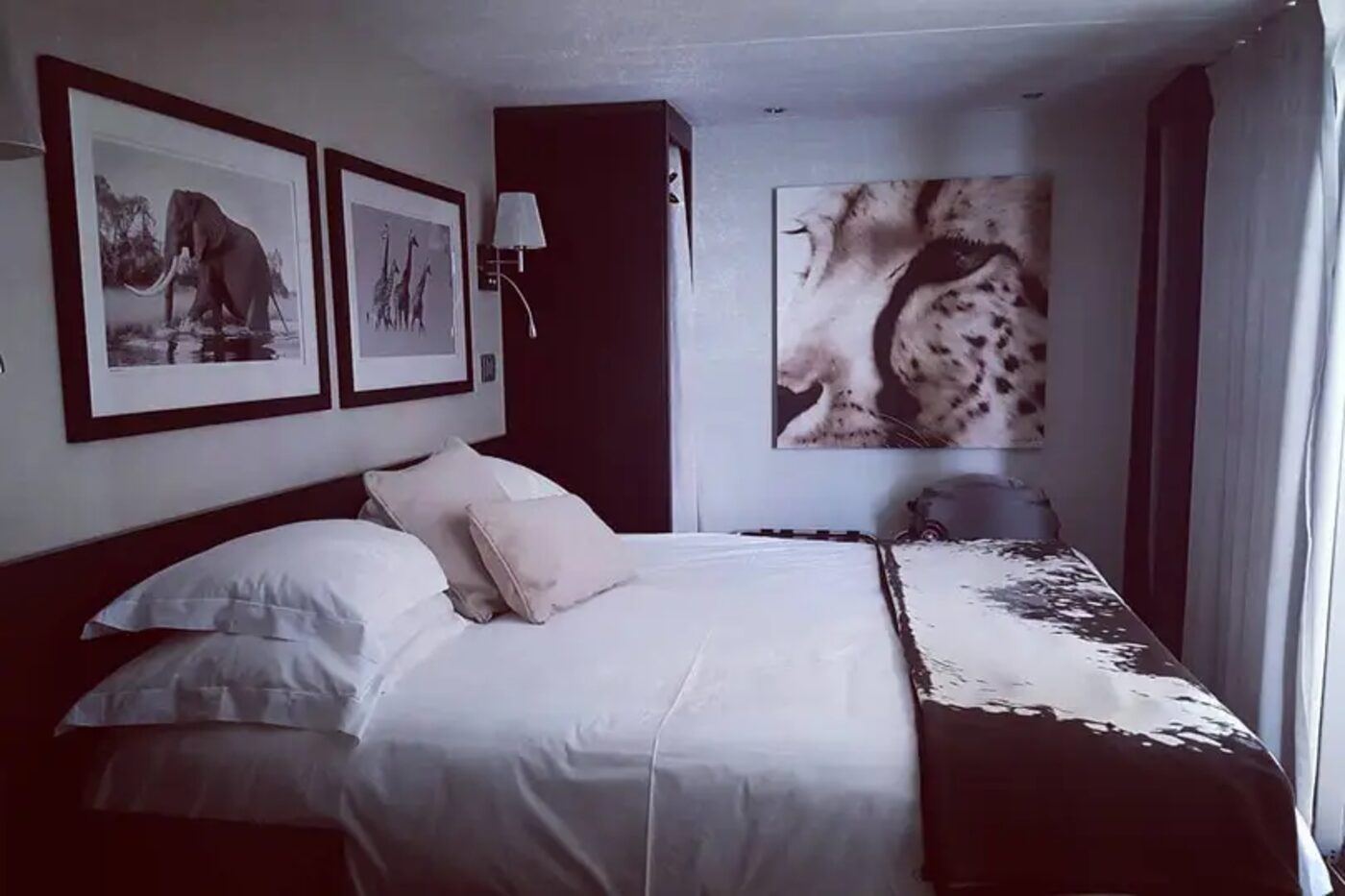 Upscale lodge bedroom with framed wildlife prints on the walls