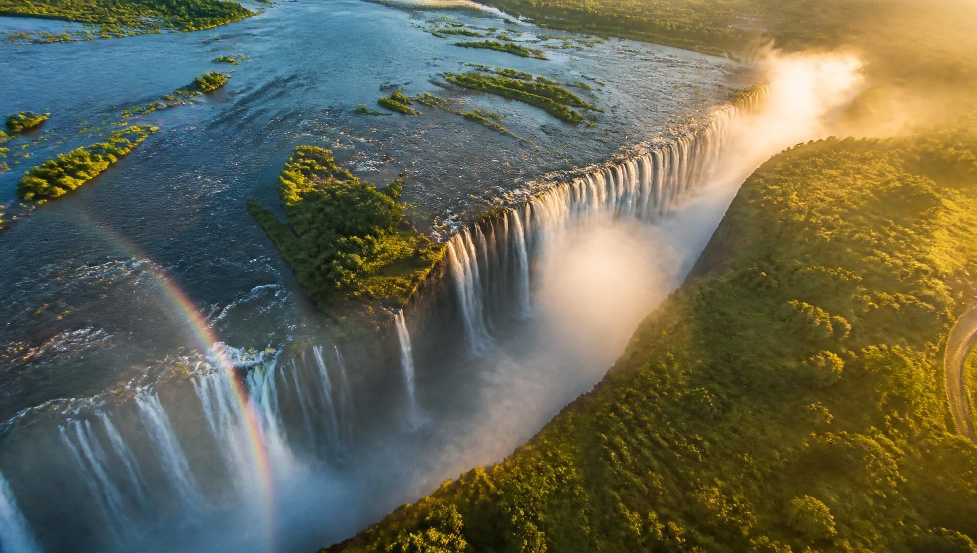 Aerial view of Victoria Falls and the Zambezi River in golden evening light